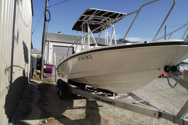 Slide: The Image of 2011 Boston Whaler 230 Dauntless boat on trailer, parked outdoors. - 2