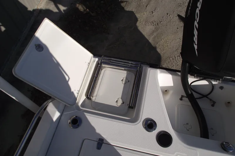 Slide: The Image of 2011 Boston Whaler 230 Dauntless boat deck with storage compartments and Mercury engine. - 23