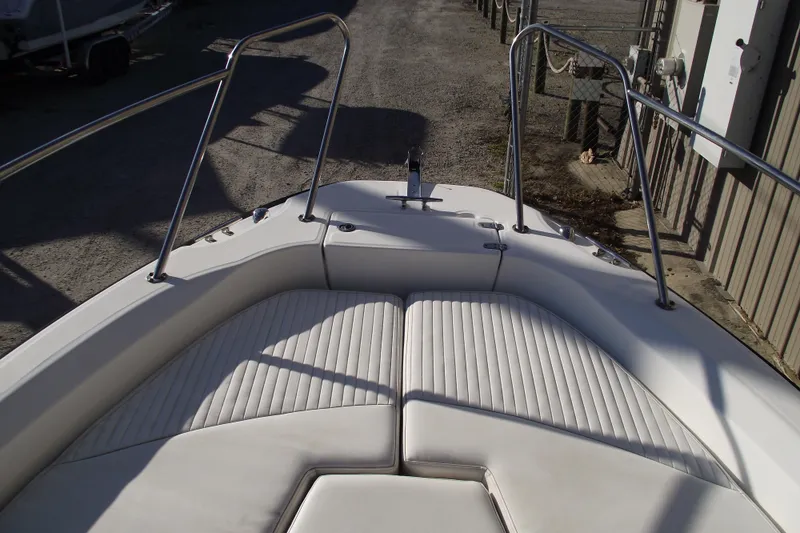 Slide: The Image of 2011 Boston Whaler 230 Dauntless boat bow with cushioned seating and stainless steel rails. - 5