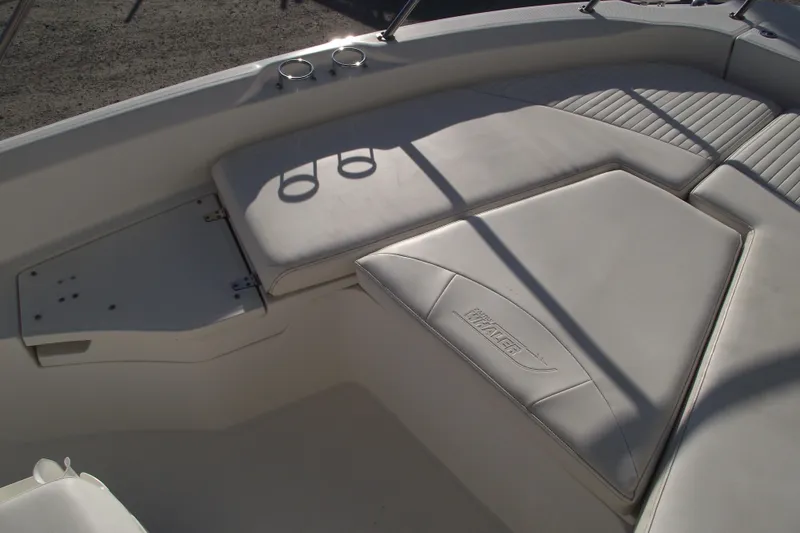 Slide: The Image of 2011 Boston Whaler 230 Dauntless boat interior with cushioned seating and cup holders. - 6