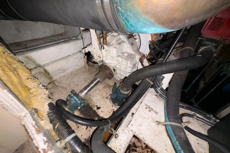 Slide: The Image of Engine compartment of 1988 Bayliner 3587 Motoryacht with visible hoses and components. - 104