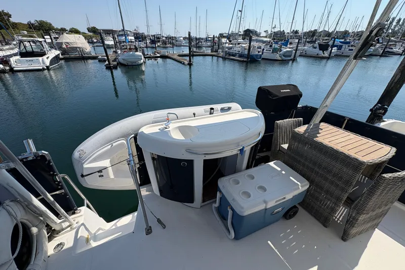 Slide: The Image of 1988 Bayliner 3587 Motoryacht docked, featuring deck setup with cooler and seating. - 23