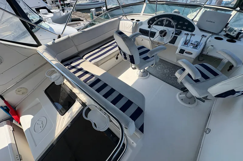 Slide: The Image of 1988 Bayliner 3587 Motoryacht cockpit with striped seating and modern navigation equipment. - 27