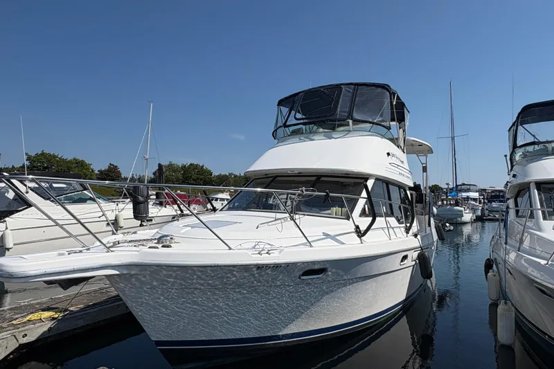 Slide: The Image of 1988 Bayliner 3587 Motoryacht docked at marina under clear blue sky. - 3