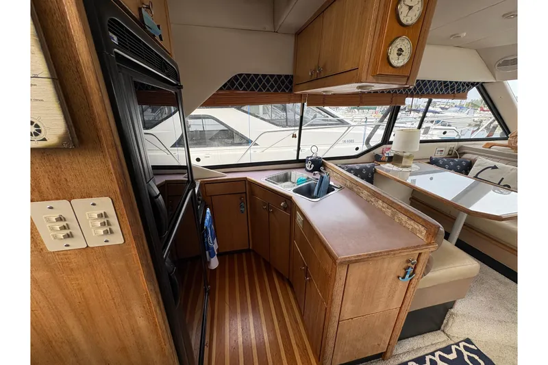 Slide: The Image of 1988 Bayliner 3587 Motoryacht interior with kitchen, dining area, and wood cabinetry. - 41