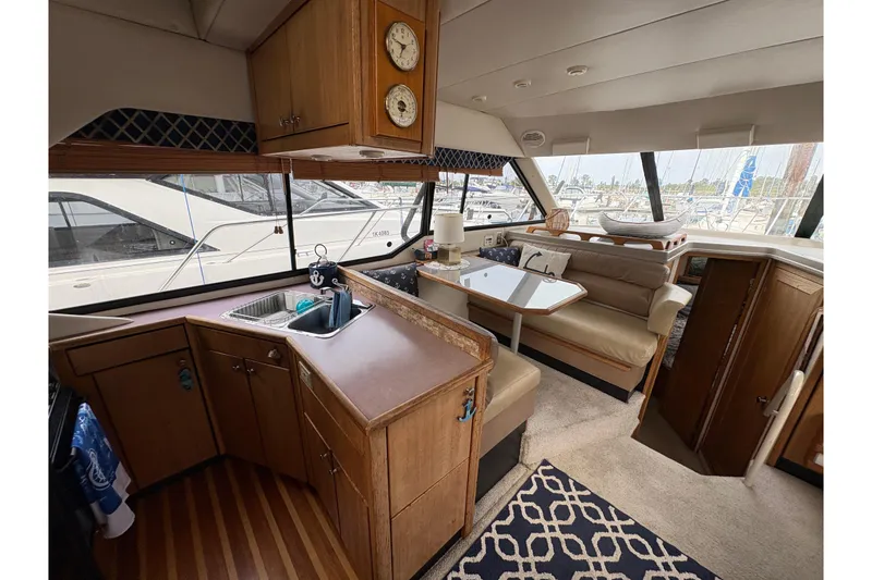 Slide: The Image of 1988 Bayliner 3587 Motoryacht interior with kitchen, dining area, and large windows. - 43