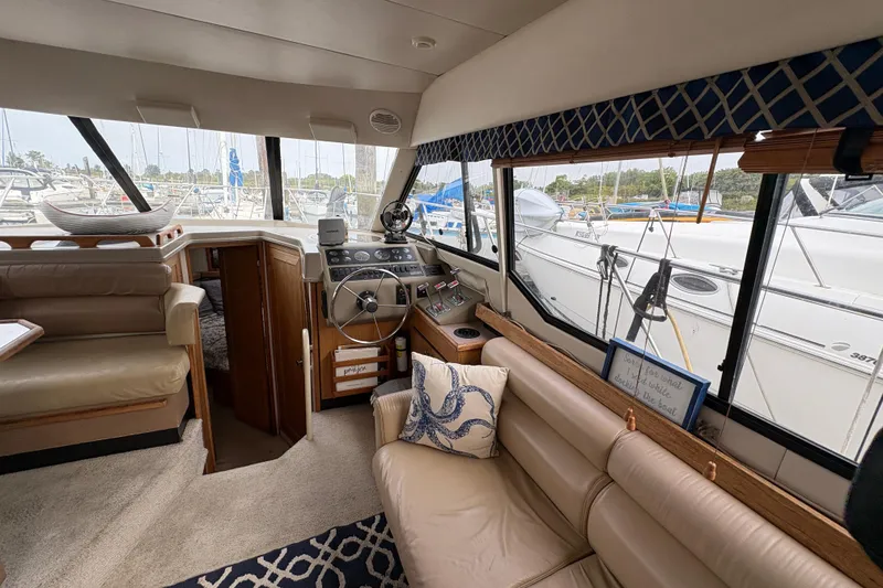 Slide: The Image of Interior of 1988 Bayliner 3587 Motoryacht with helm, seating, and marina view. - 47