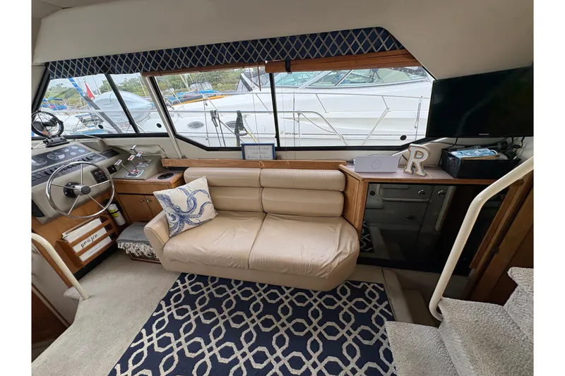 Slide: The Image of 1988 Bayliner 3587 Motoryacht interior with leather sofa, nautical decor, and steering wheel. - 50