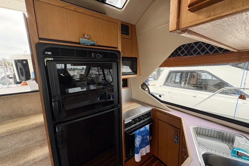 Slide: The Image of Interior of 1988 Bayliner 3587 Motoryacht kitchen with appliances and window view. - 59