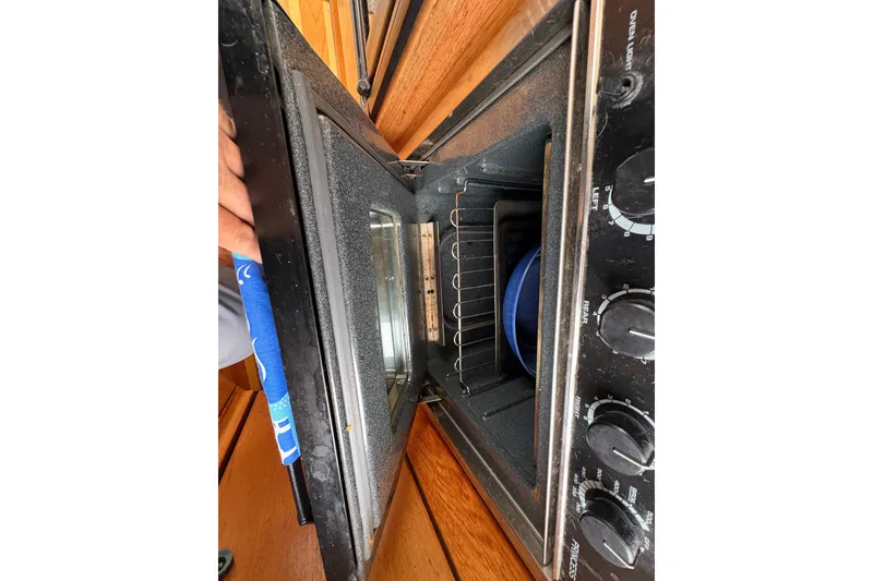 Slide: The Image of Open oven door on 1988 Bayliner 3587 Motoryacht, showing interior and control knobs. - 62