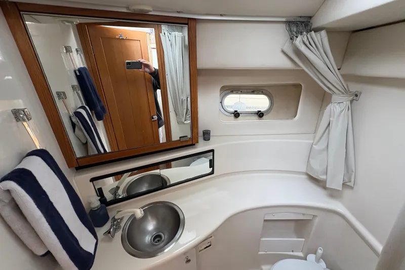 Slide: The Image of 1988 Bayliner 3587 Motoryacht bathroom with sink, mirror, and porthole window. - 73