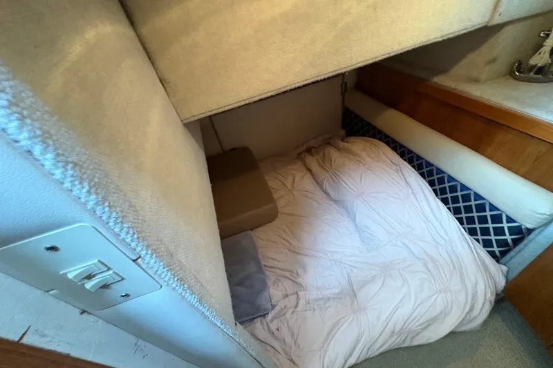 Slide: The Image of Cozy sleeping area in 1988 Bayliner 3587 Motoryacht with soft bedding and wooden accents. - 84
