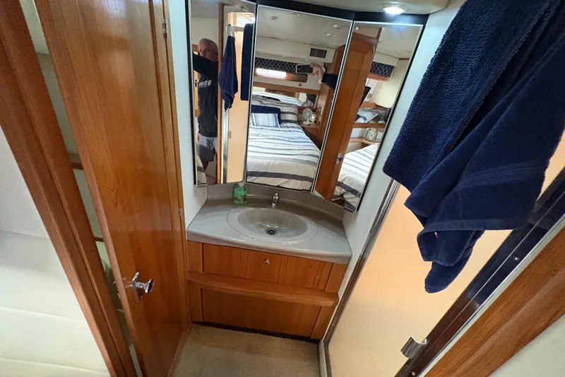 Slide: The Image of 1988 Bayliner 3587 Motoryacht bathroom with sink, mirror, and wooden cabinetry. - 93