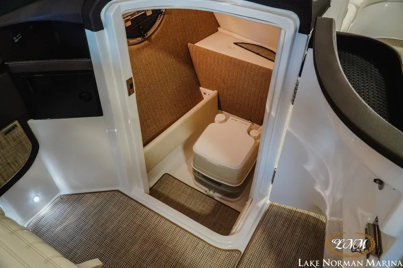 Slide: The Image of 2021 Cobalt R5 boat interior with compact toilet and carpeted flooring. - 15