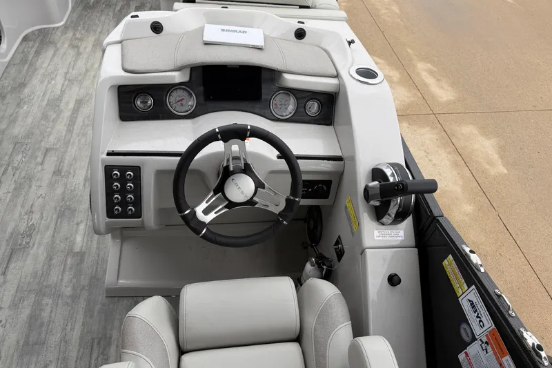 Slide: The Image of 2023 Crest Caribbean LX 230 boat helm with steering wheel and control panel. - 11