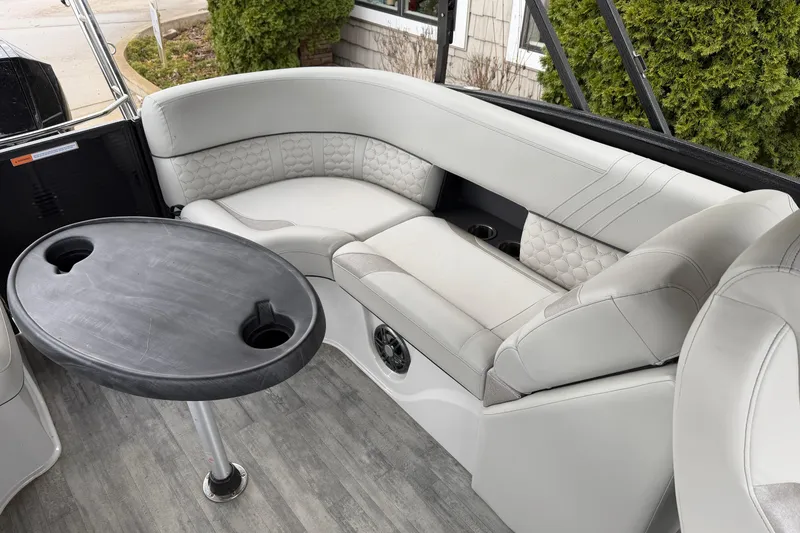 Slide: The Image of Luxurious seating area on 2023 Crest Caribbean LX 230 boat with table and cup holders. - 8