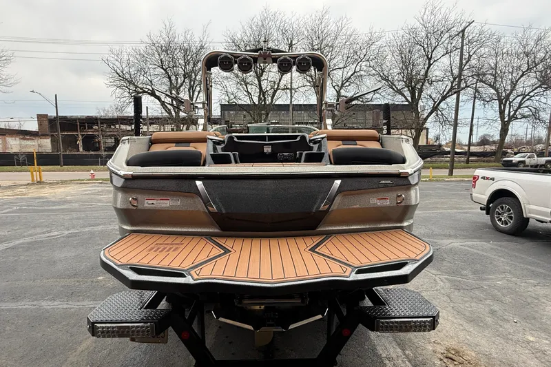 Slide: The Image of 2021 MasterCraft X26 boat with teak swim platform, parked outdoors. - 10