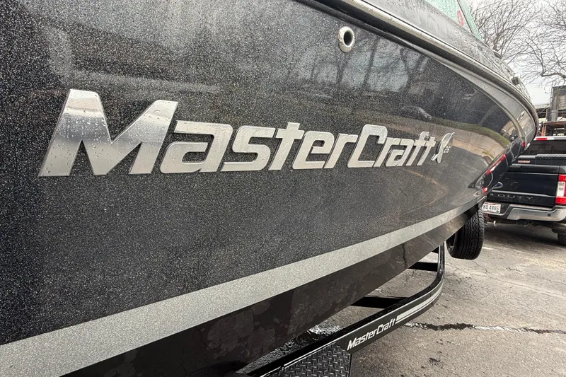 Slide: The Image of 2021 MasterCraft X26 boat with sleek black exterior and logo detail. - 12