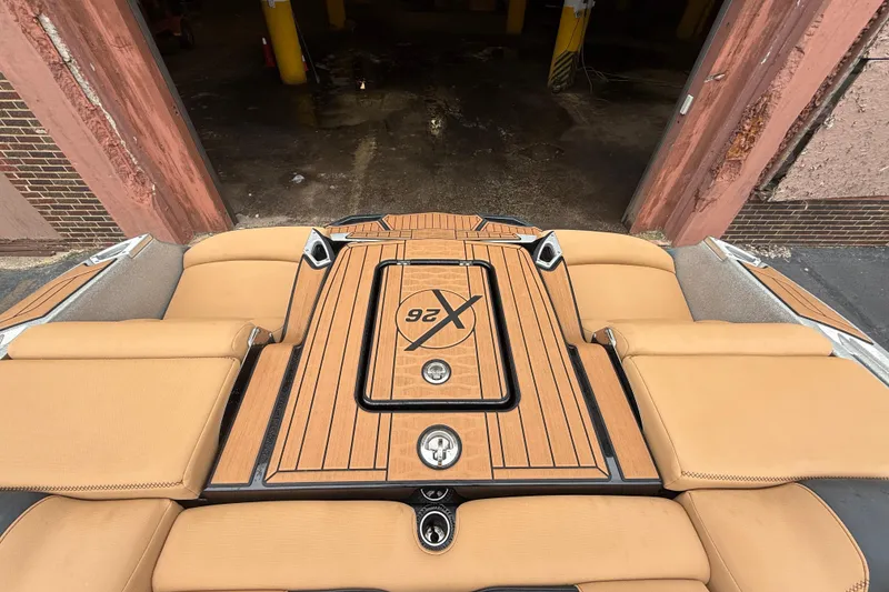 Slide: The Image of 2021 MasterCraft X26 boat with tan seating and teak deck in a garage. - 17