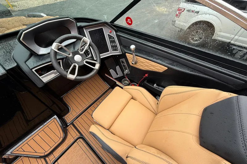 Slide: The Image of 2021 MasterCraft X26 boat interior with tan seating and modern steering console. - 22