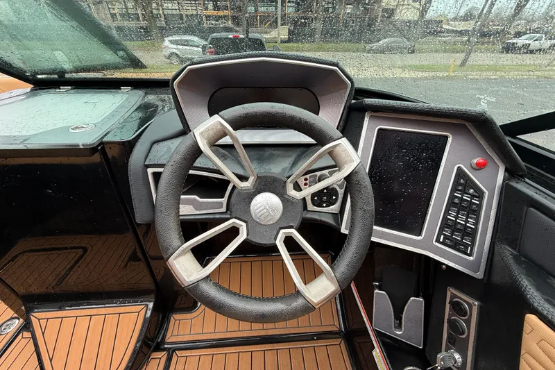 Slide: The Image of 2021 MasterCraft X26 boat dashboard with steering wheel and control panel. - 23