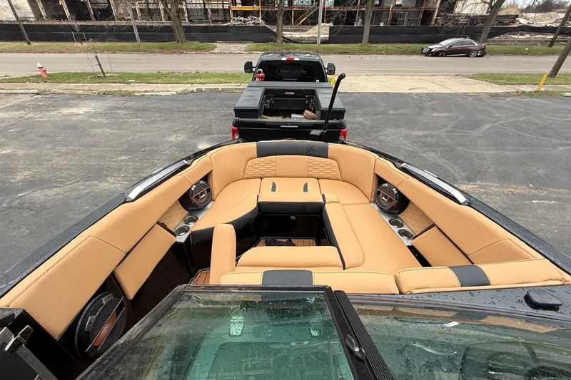 Slide: The Image of 2021 MasterCraft X26 boat interior with tan seating, parked on a trailer. - 28