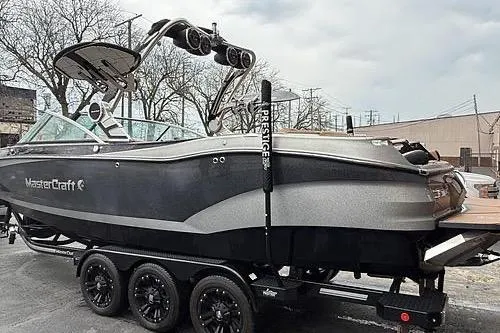 Slide: The Image of 2021 MasterCraft X26 boat on trailer, featuring sleek design and advanced wakeboard tower. - 3