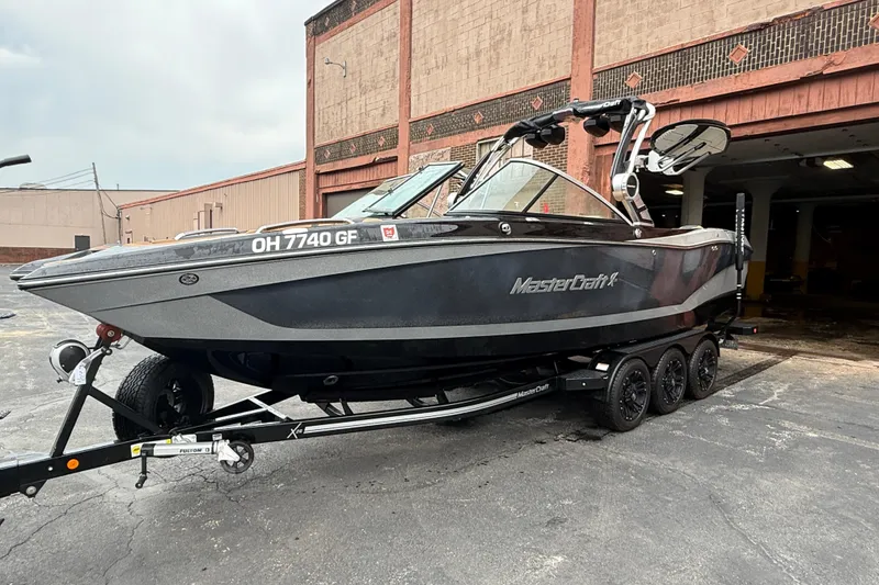 Slide: The Image of 2021 MasterCraft X26 boat on trailer, parked outside a brick building. - 5