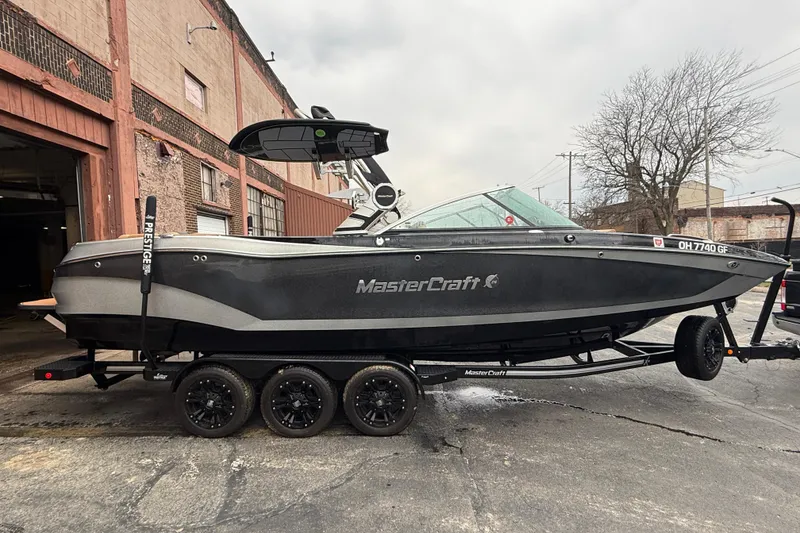 Slide: The Image of 2021 MasterCraft X26 boat on trailer, parked near industrial building. - 9