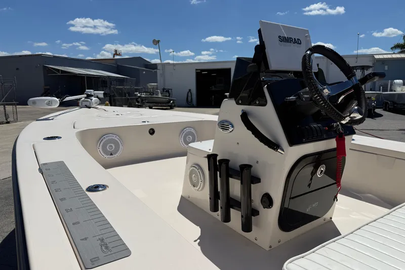 Slide: The Image of 2006 Hewes Redfisher 21 boat with Simrad electronics, docked under a clear blue sky. - 10