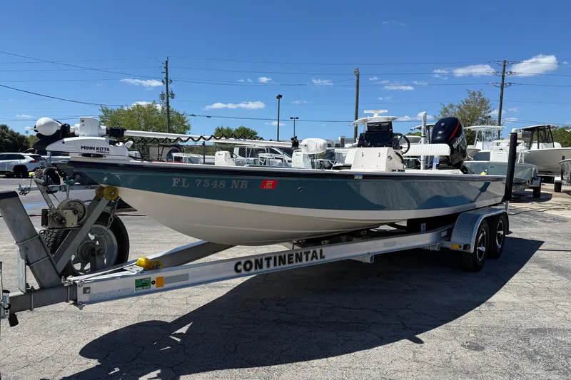 Slide: The Image of 2006 Hewes Redfisher 21 boat on trailer, parked outdoors under clear blue sky. - 11