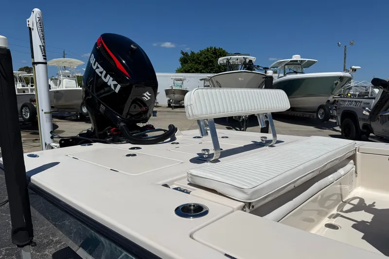 Slide: The Image of 2006 Hewes Redfisher 21 boat with Suzuki engine, docked under clear blue sky. - 3