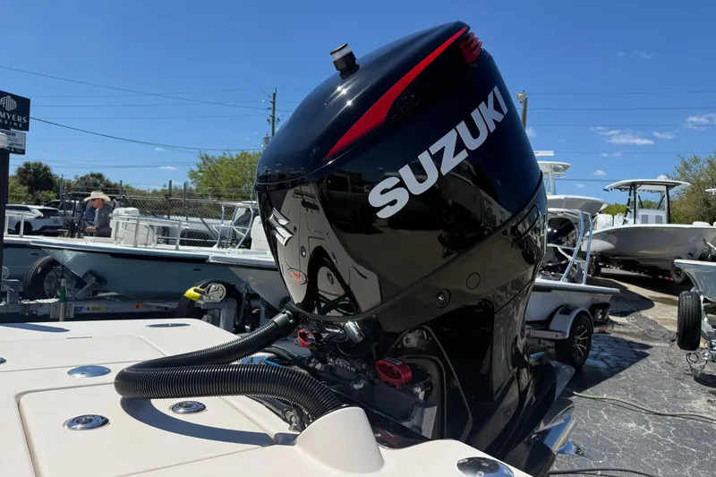 Slide: The Image of 2006 Hewes Redfisher 21 boat with Suzuki outboard motor in a marina setting. - 9