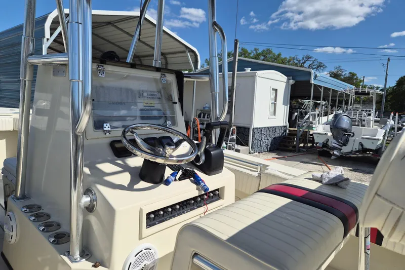 Slide: The Image of 2008 Contender 23 Tournament boat dashboard with steering wheel and controls, parked outdoors. - 5