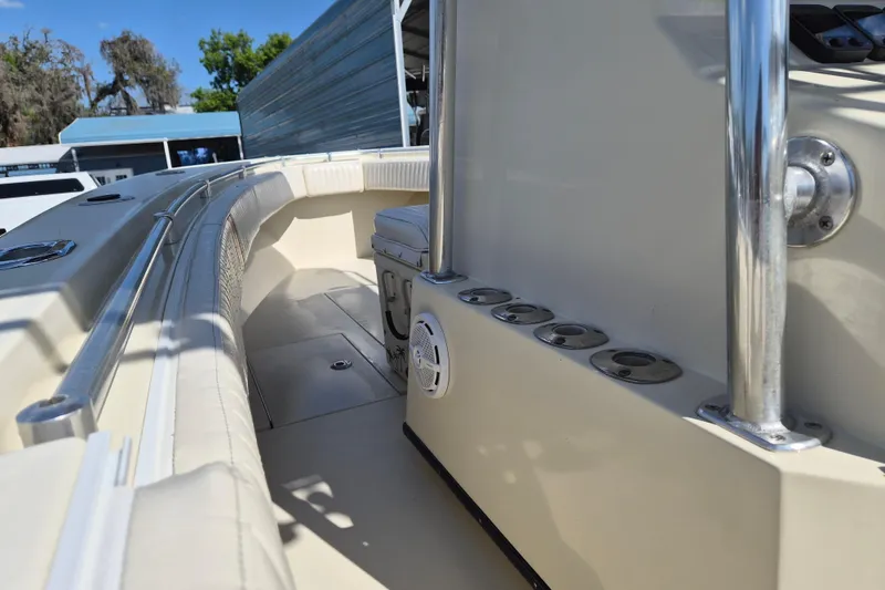 Slide: The Image of 2008 Contender 23 Tournament boat interior with rod holders and seating, docked outdoors. - 7
