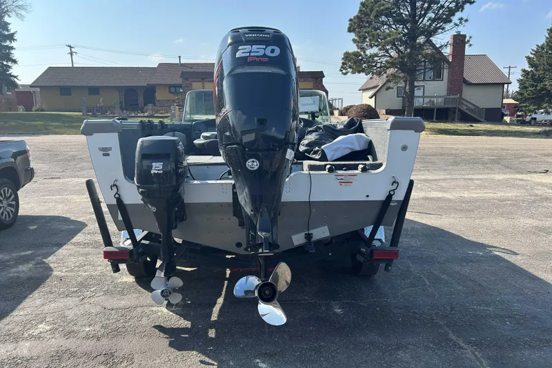 Slide: The Image of 2018 Lund 2075 Tyee boat with dual outboard motors in a parking lot. - 5