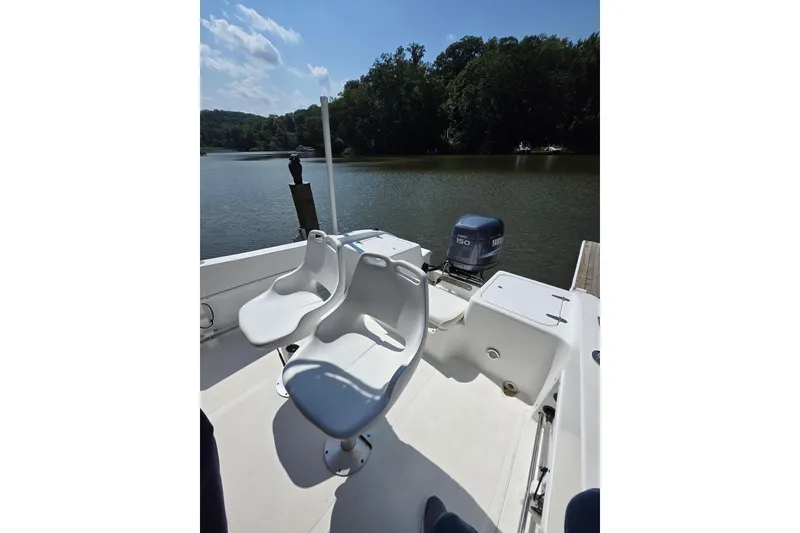Slide: The Image of 2003 Sea Pro 206 Center Console boat with seating, docked on a calm lake. - 6