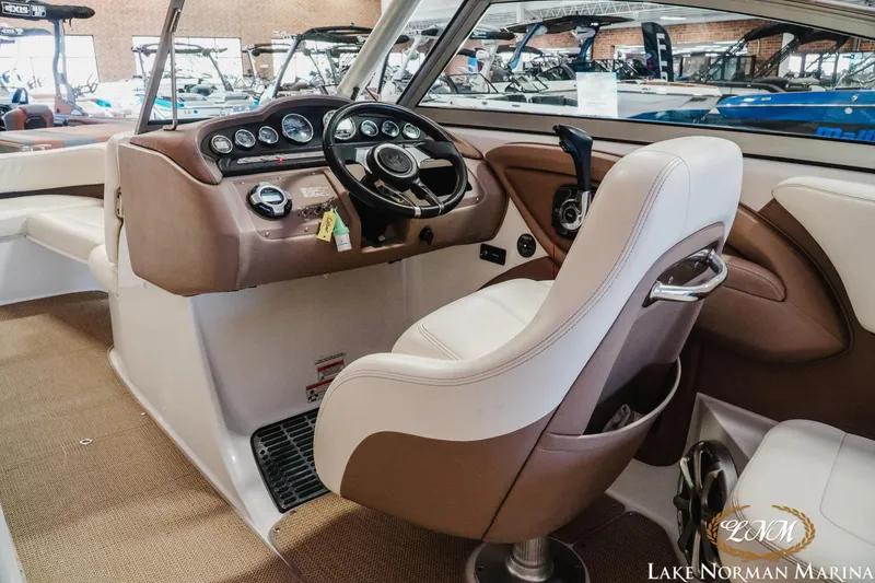Slide: The Image of Interior of a 2011 Cobalt 242 WSS boat with steering wheel and dashboard. - 11