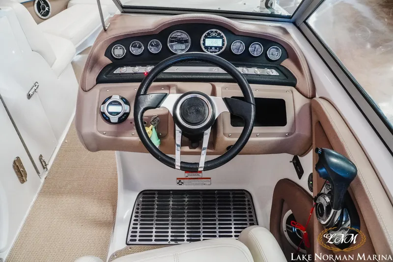 Slide: The Image of 2011 Cobalt 242 WSS boat dashboard with steering wheel and control panel. - 12