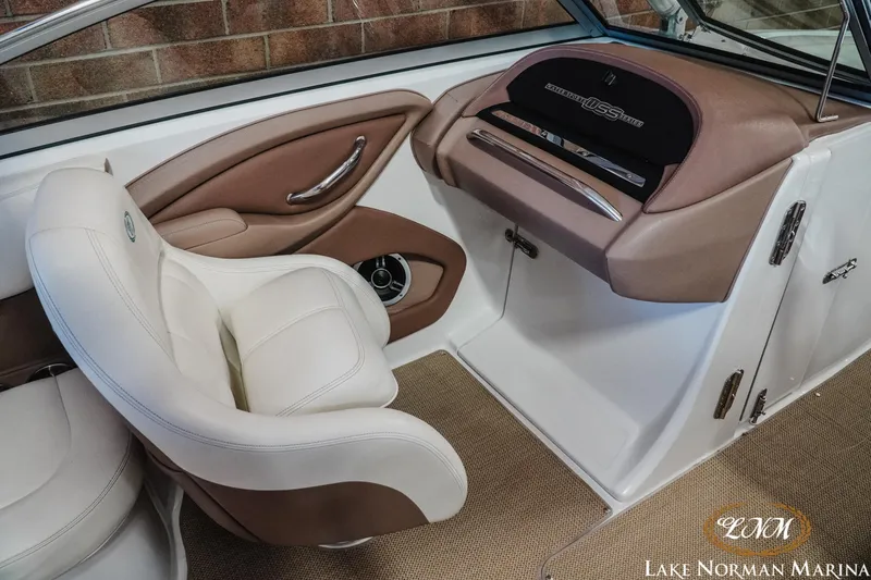 Slide: The Image of Interior of a 2011 Cobalt 242 WSS boat with beige seating and dashboard. - 13