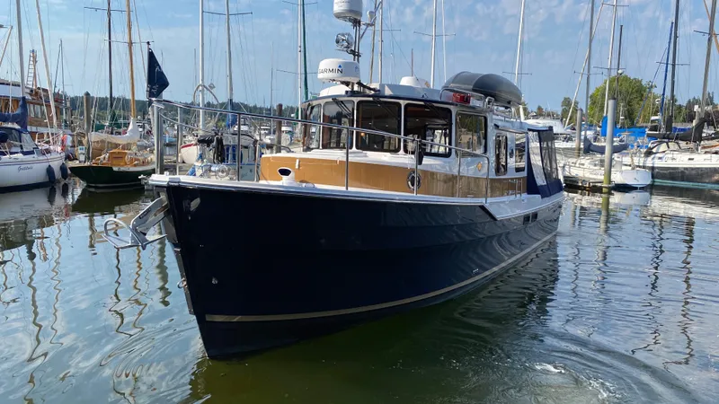 The Image of 2018 Ranger Tugs R-31 S boat docked in a marina with sailboats. - 0