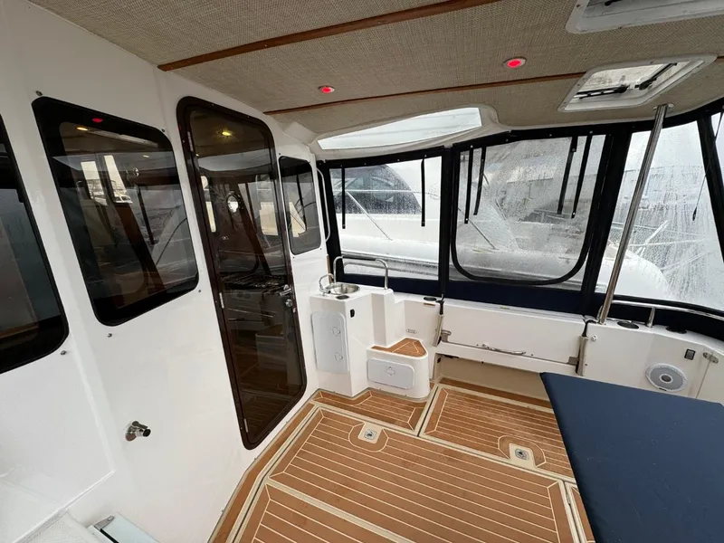 Slide: The Image of 2018 Ranger Tugs R-31S Ranger Tug interior with wood flooring and large windows. - 10