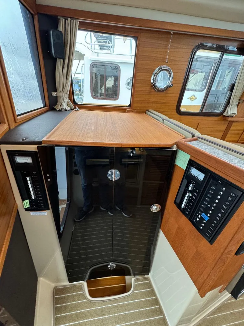 Slide: The Image of 2018 Ranger Tugs R-31S Ranger Tug interior with control panels and wooden cabinetry. - 21