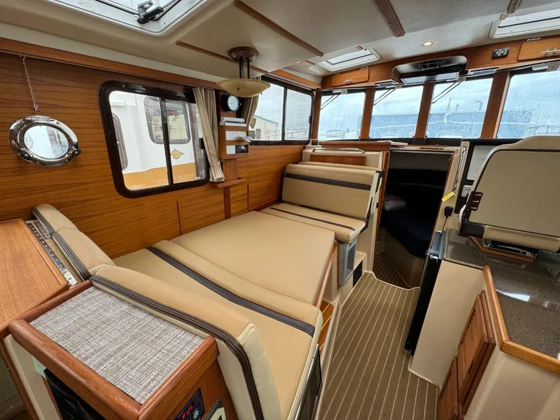 Slide: The Image of 2018 Ranger Tugs R-31S Ranger Tug interior with convertible seating and wood finishes. - 26