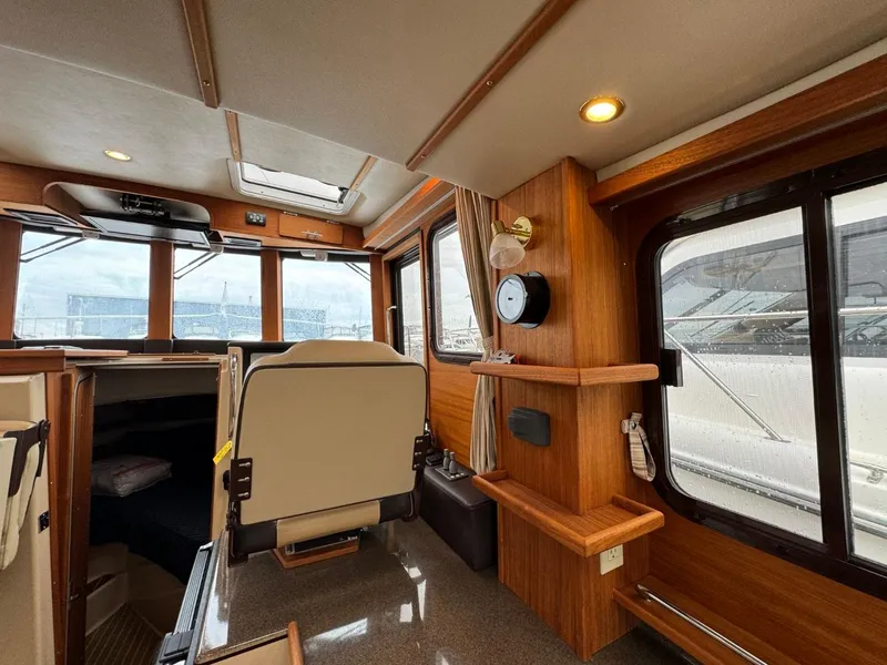 Slide: The Image of 2018 Ranger Tugs R-31S Ranger Tug interior with helm, seating, and wooden cabinetry. - 27
