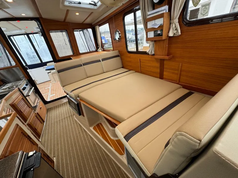 Slide: The Image of 2018 Ranger Tugs R-31S Ranger Tug interior with beige seating and wooden accents. - 33