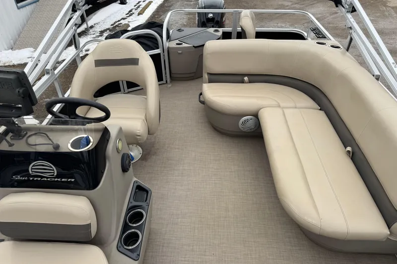 Slide: The Image of 2020 Sun Tracker Bass Buggy 18 DLX interior with beige seating and steering console. - 7