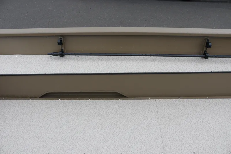 Slide: The Image of 2026 Smoker Craft Sportsman 1660 boat interior with rod holder and textured flooring. - 11