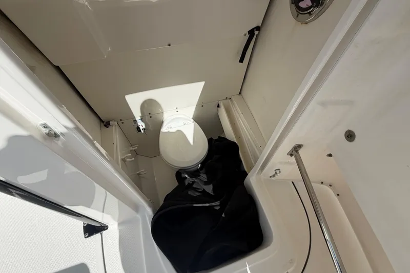 Slide: The Image of 2020 Robalo R272 Center Console boat interior with toilet and storage area. - 11