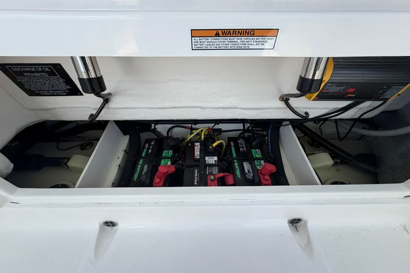 Slide: The Image of 2020 Robalo R272 Center Console battery compartment with warning labels and wiring. - 17